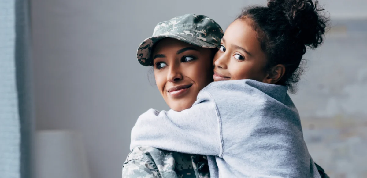 Militärische Mutter, die ihre Tochter umarmt