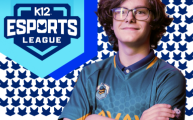 Eine Person in einem blaugrünen E-Sport-Trikot steht mit verschränkten Armen vor einem gemusterten Hintergrund mit sich wiederholenden blauen Fuchs-Symbolen. Links ist ein großes blaues, schildförmiges Logo mit der Aufschrift „K12 Esports League” und einem stilisierten Fuchs-Emblem über dem Text zu sehen.